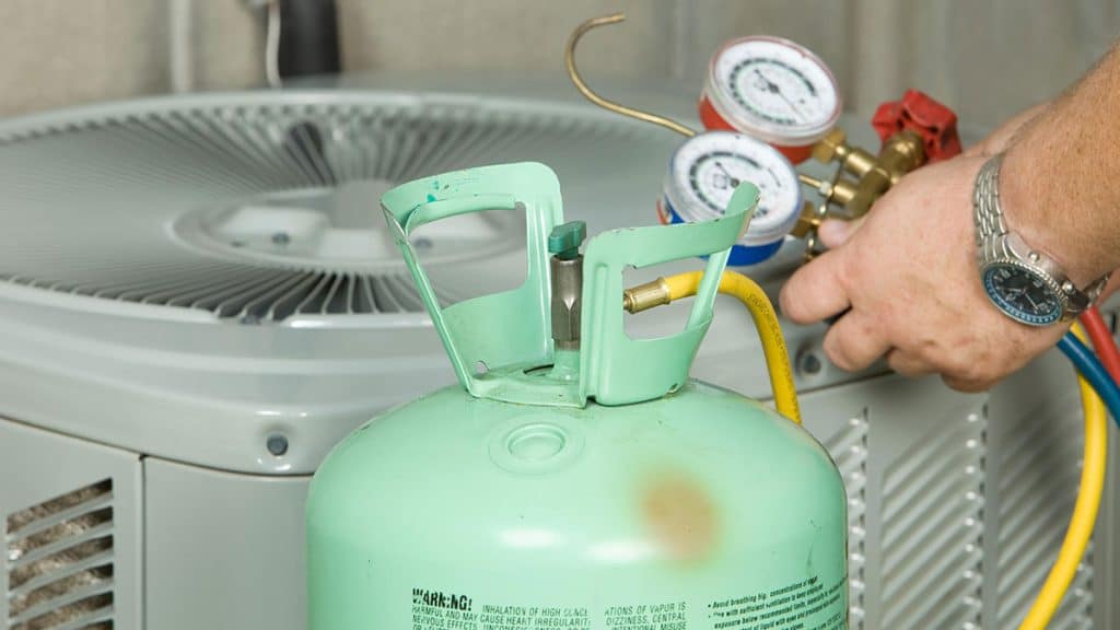 Image of an HVAC technician changing out refrigerant in ac unit Ocala.